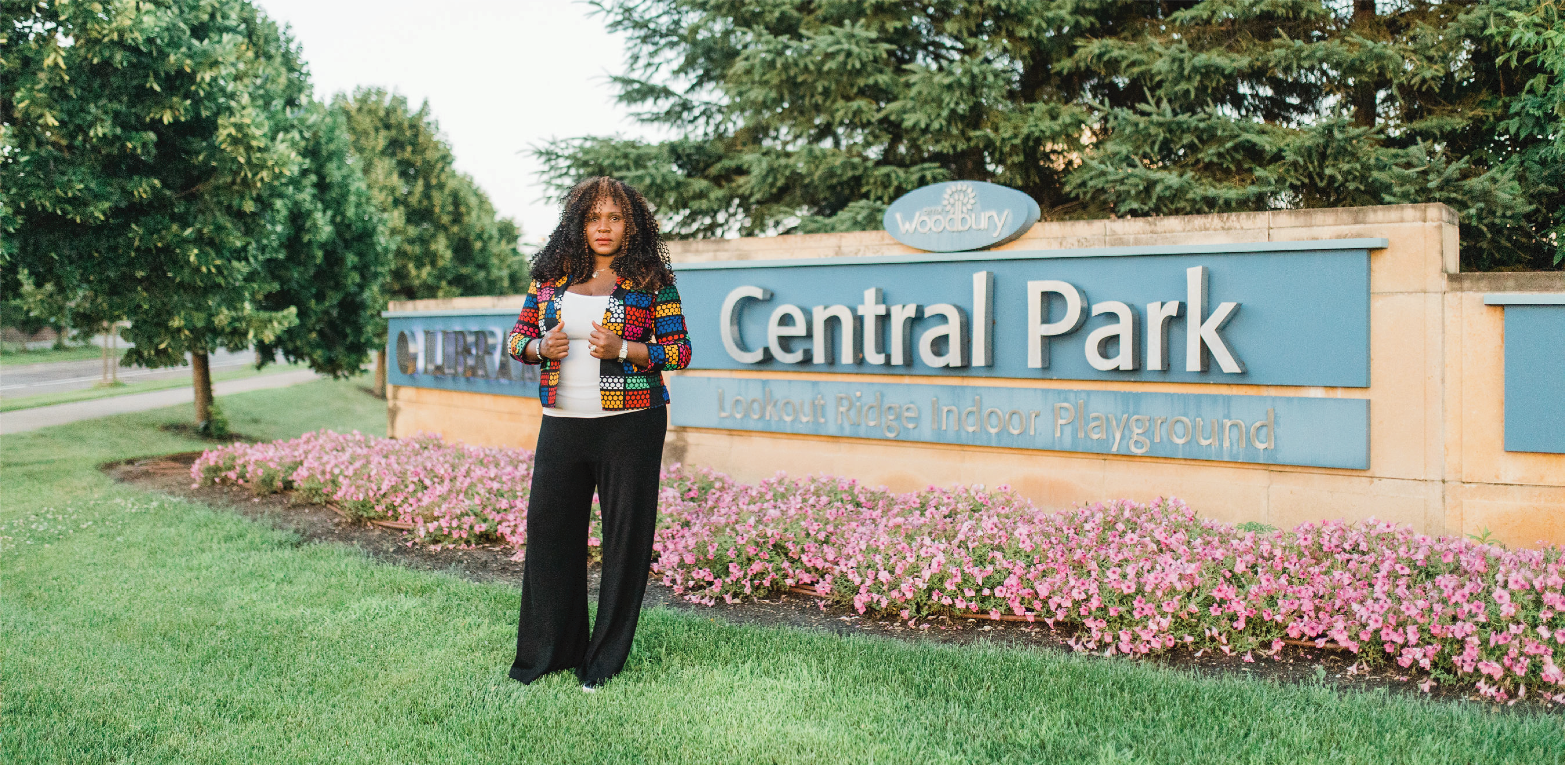 Candidate Temmy Olasimbo stands in front of Woodbury Central Park sign.